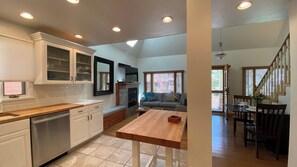 A modern kitchen with white cabinets, a wooden countertop, and a built-in dishwasher. - Woodside Getaway by Avantstay Character Home Close To Park City Resort w/ Hot Tub (Park City)