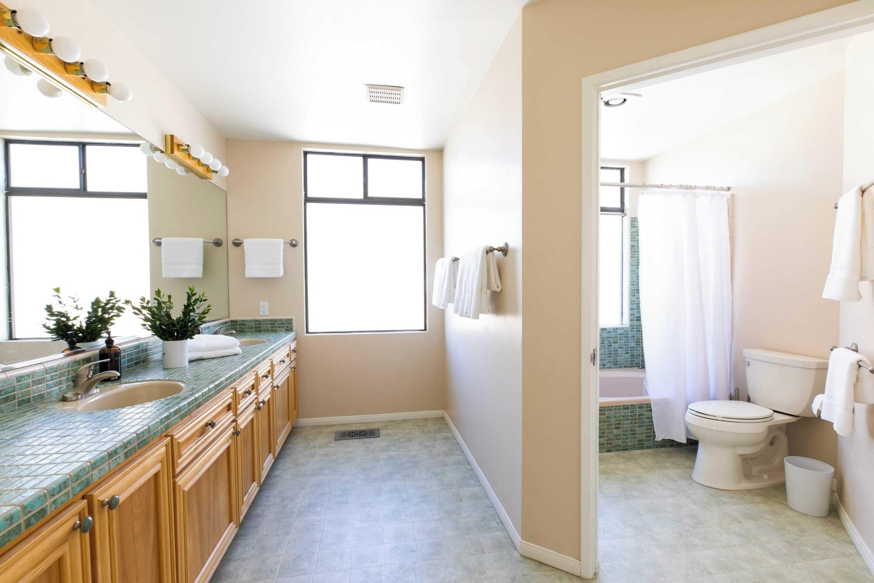 Un bagno moderno con un ampio specchio, un mobile lavabo e una zona doccia.