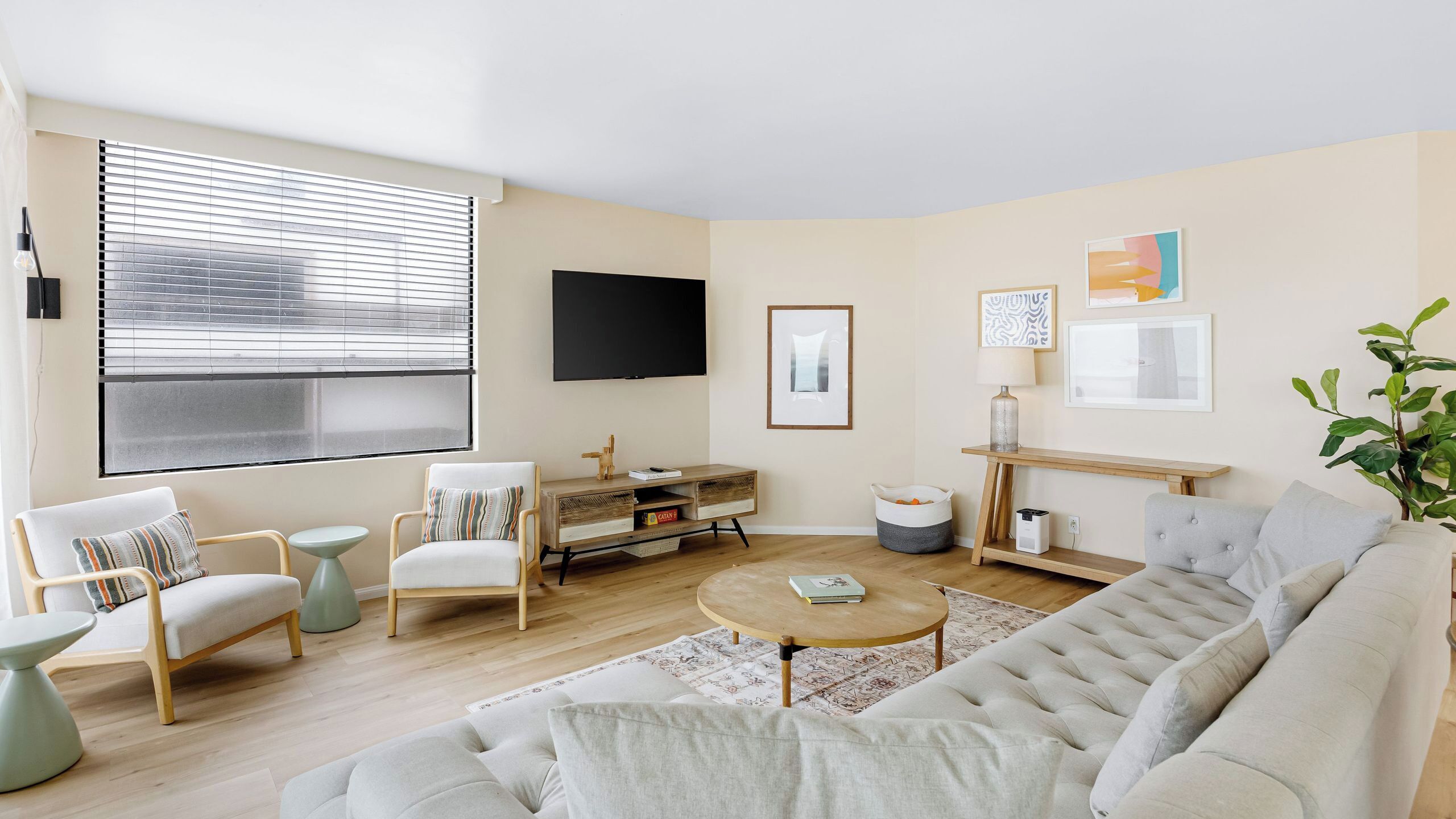 A living room with a sofa, chairs, a coffee table, a TV, and a bookshelf.