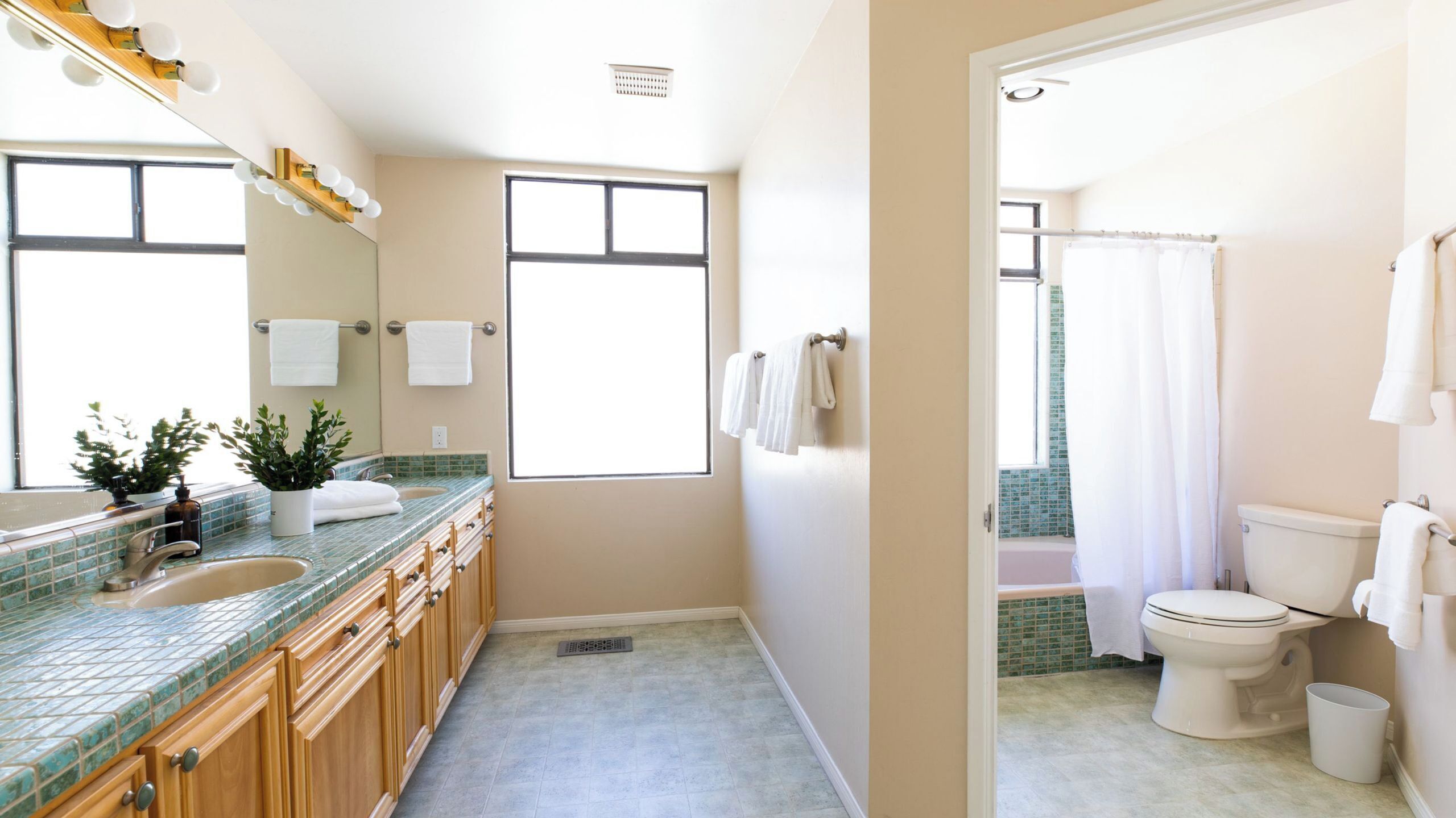 A modern bathroom with a large window, a shower, and a toilet.