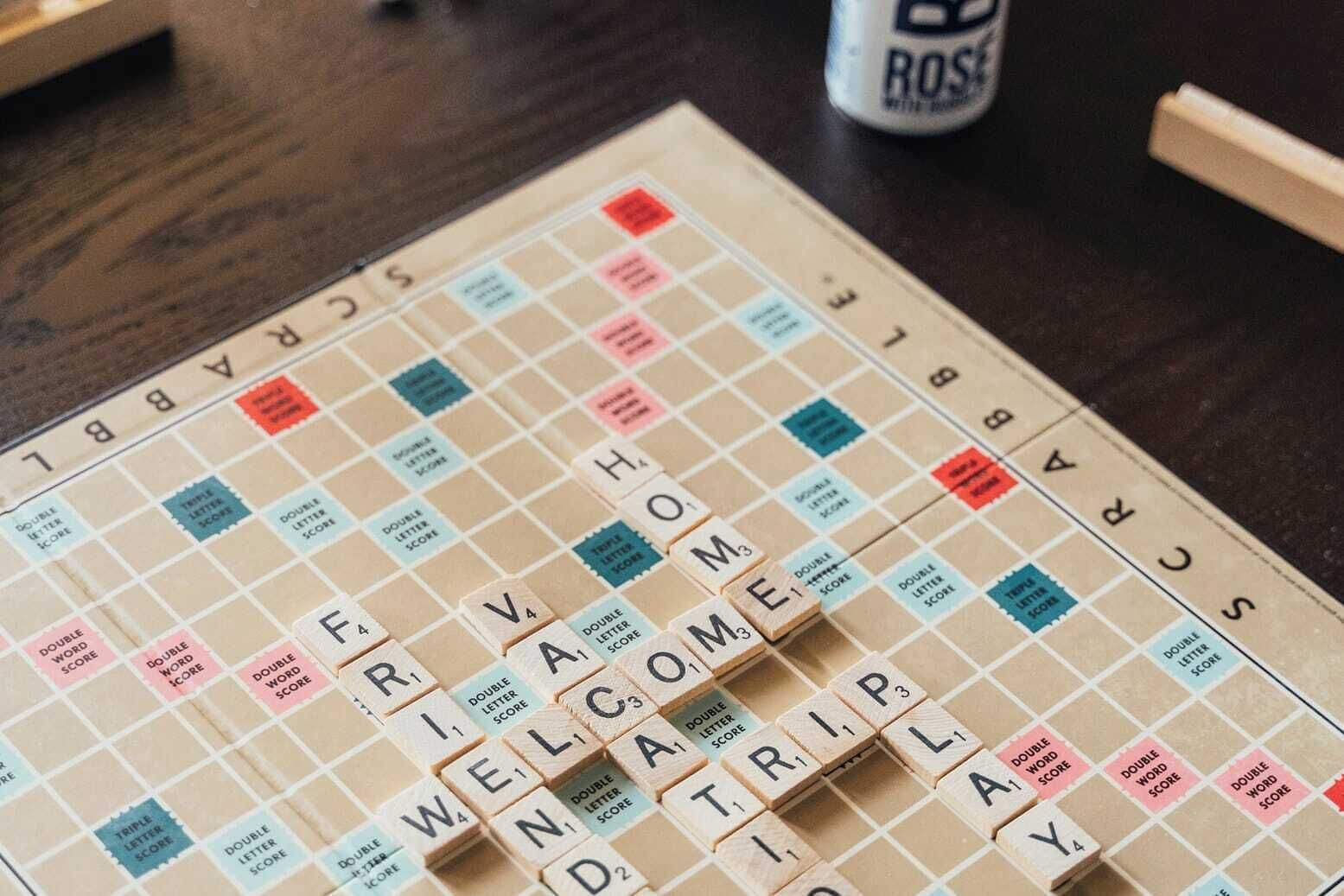 A Scrabble game board with tiles arranged to spell "WELCOME TRAVEL".