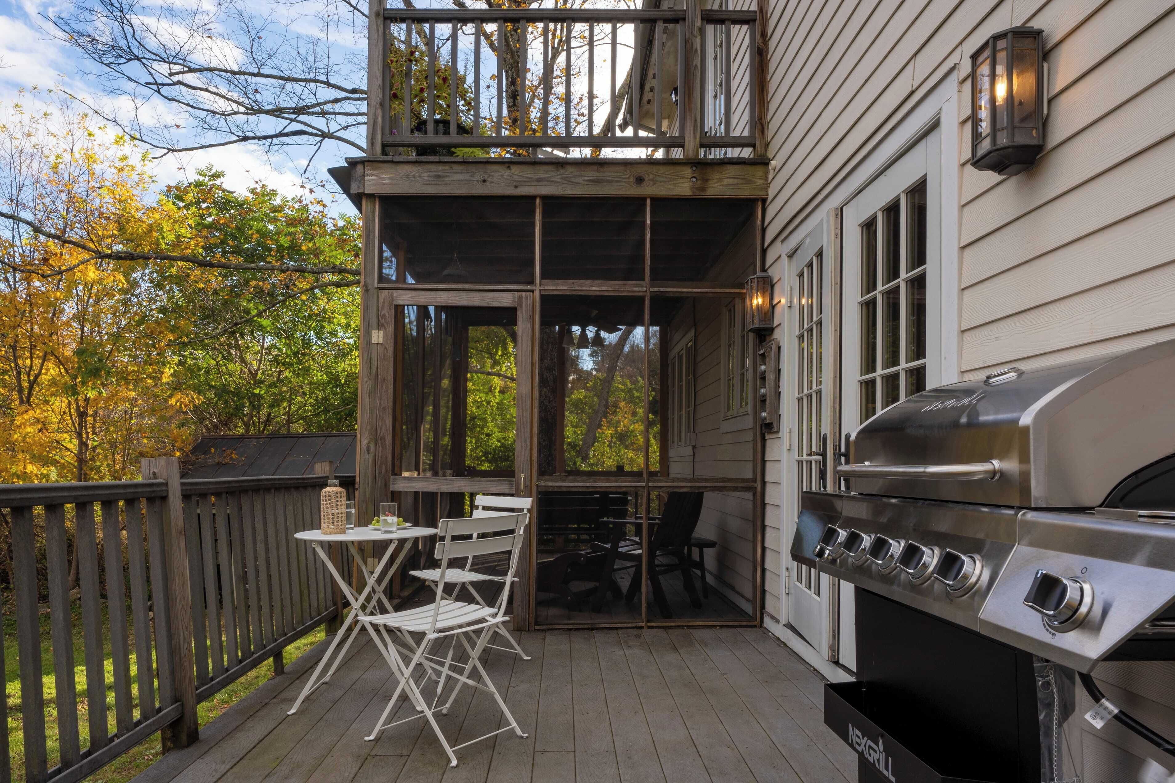 A covered outdoor patio with a grill, a table, and chairs.