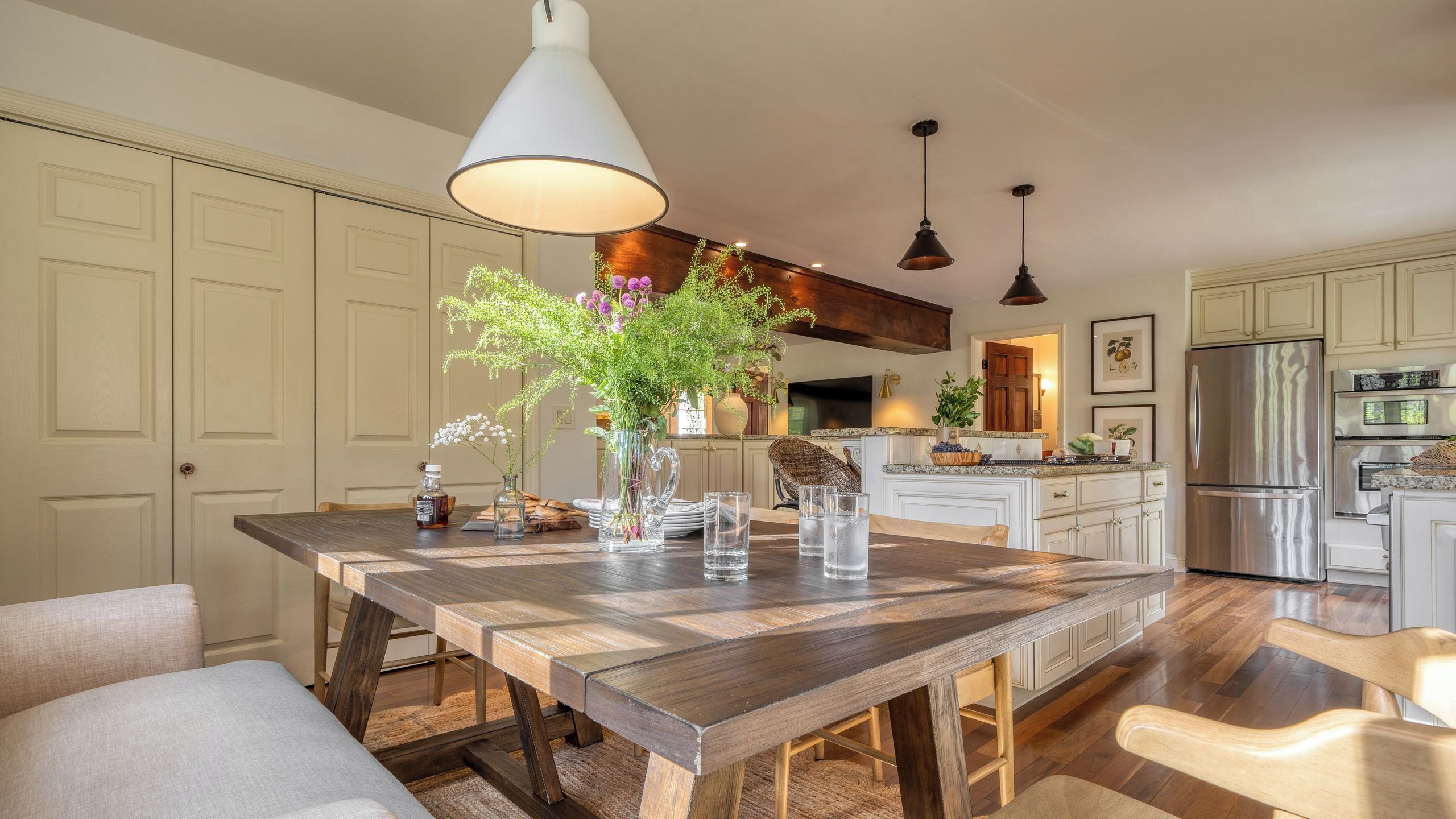A spacious kitchen with a large island, wooden flooring, and modern appliances.