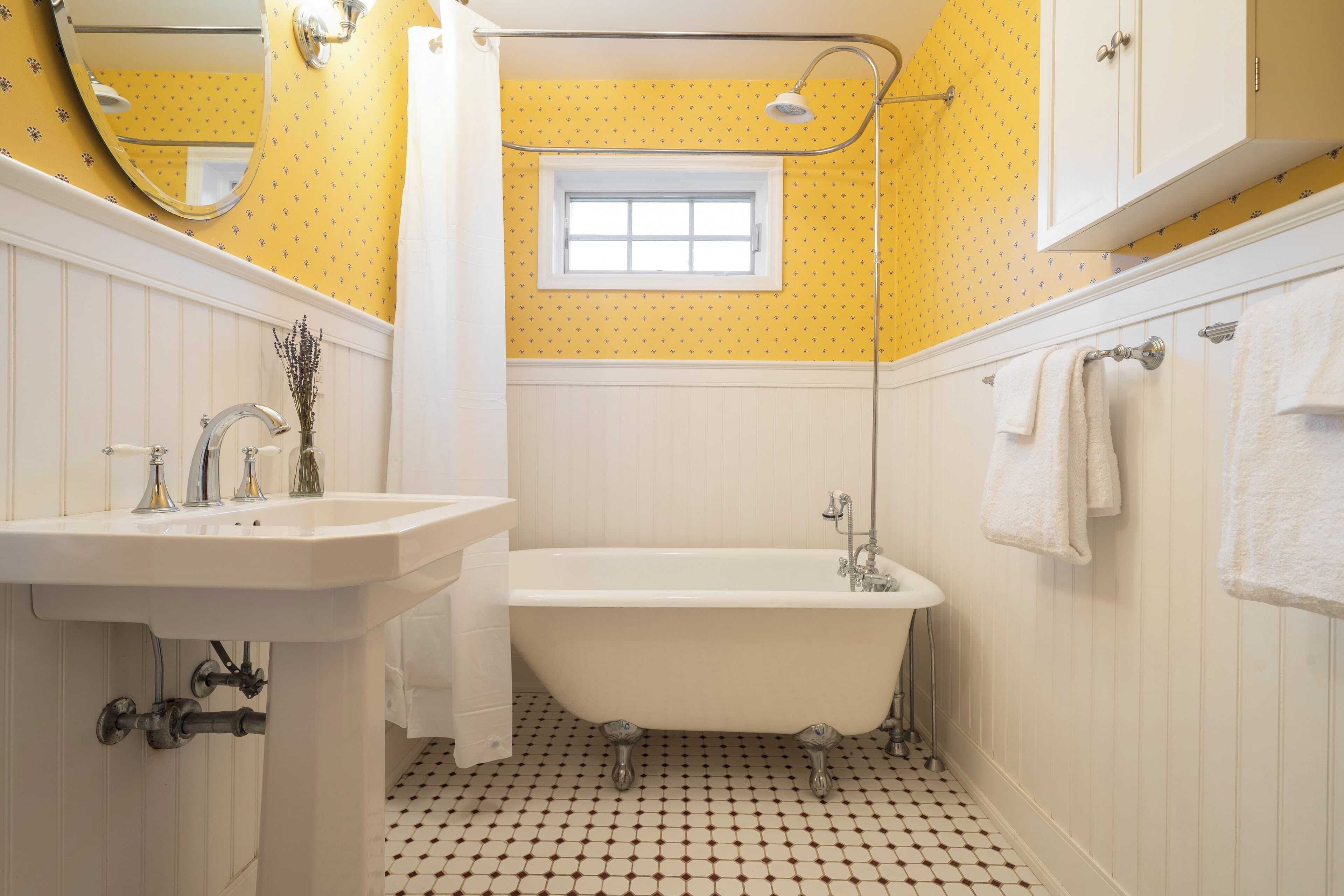 Un baño con una bañera blanca, un lavamanos y una ventana.