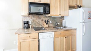 A kitchen with wooden cabinets, a microwave, a coffee maker, a sink, and a dishwasher. - Viking Lodge 117 by Avantstay Ski Home, Near Town Park & Downtown (Telluride)
