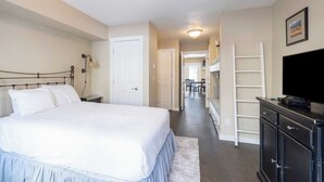 A bedroom with a large bed, a dresser, a TV, and a hallway leading to a dining area. - Viking Lodge 117 by Avantstay Ski Home, Near Town Park & Downtown (Telluride)