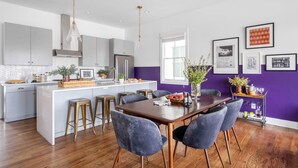A modern kitchen with a central island, grey cabinets, and pendant lighting. - Musgraves & Twain by Avantstay 2 Unit Buyout w/ 8BR in Heart of Nashville (Nashville)