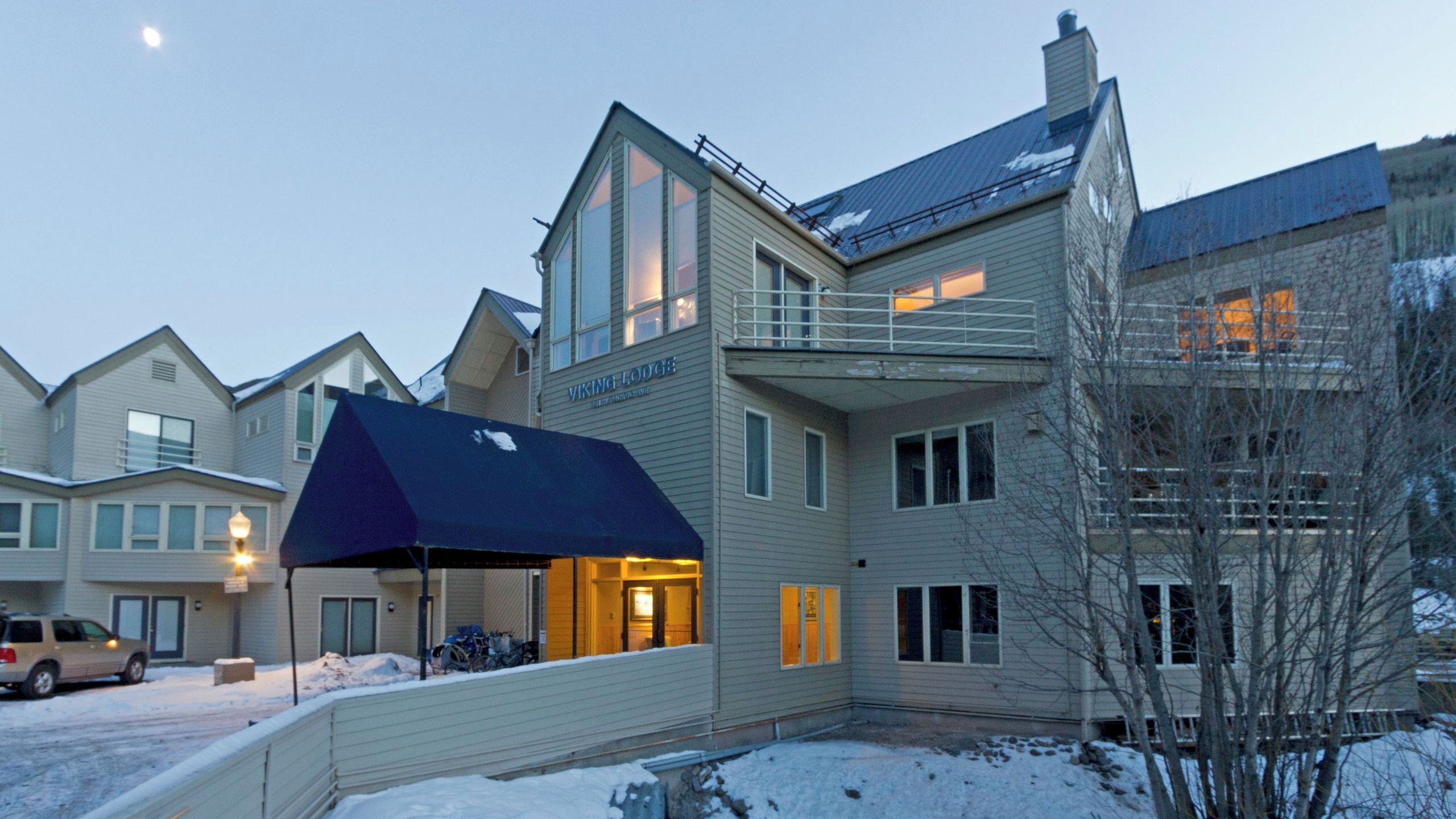 A multi-story building with a covered outdoor area, a sign reading 'VIKING LODGE,' and snow on the ground.