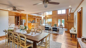 A spacious living area with a wooden dining table, chairs, and a ceiling fan. - Raven by Avantstay Entertainers Dream w/ Pool, Hot Tub, Game Room! 9 Brs! (Sullivan's Island)