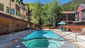 A rectangular swimming pool with a wooden deck, surrounded by buildings and trees. - Lulu City 4B by Avantstay Beautiful Condo 100 Yards From Lift #7 Permit #:3639 (Telluride)