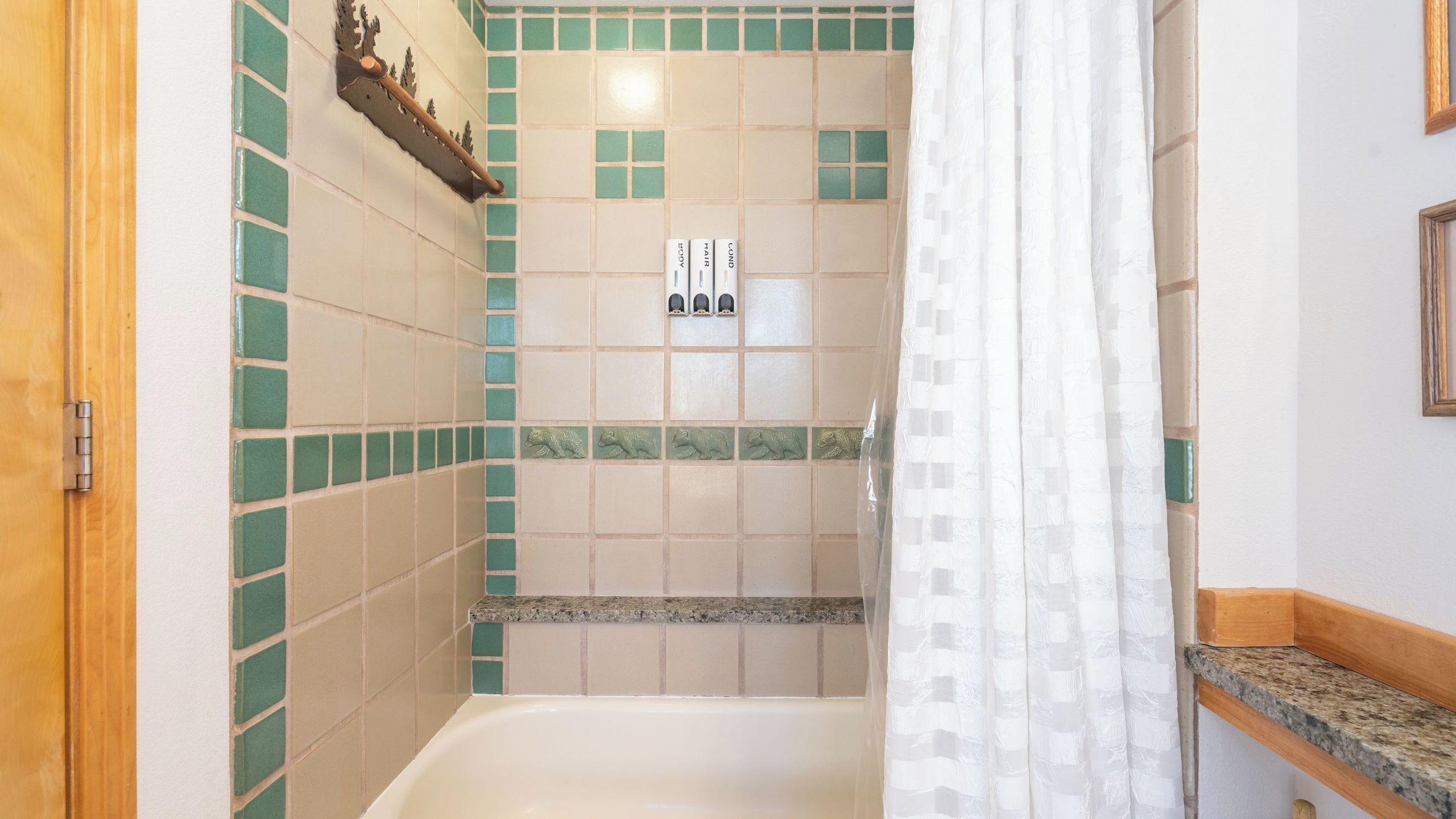 Un baño con bañera, cortina de ducha y toallero en la pared.