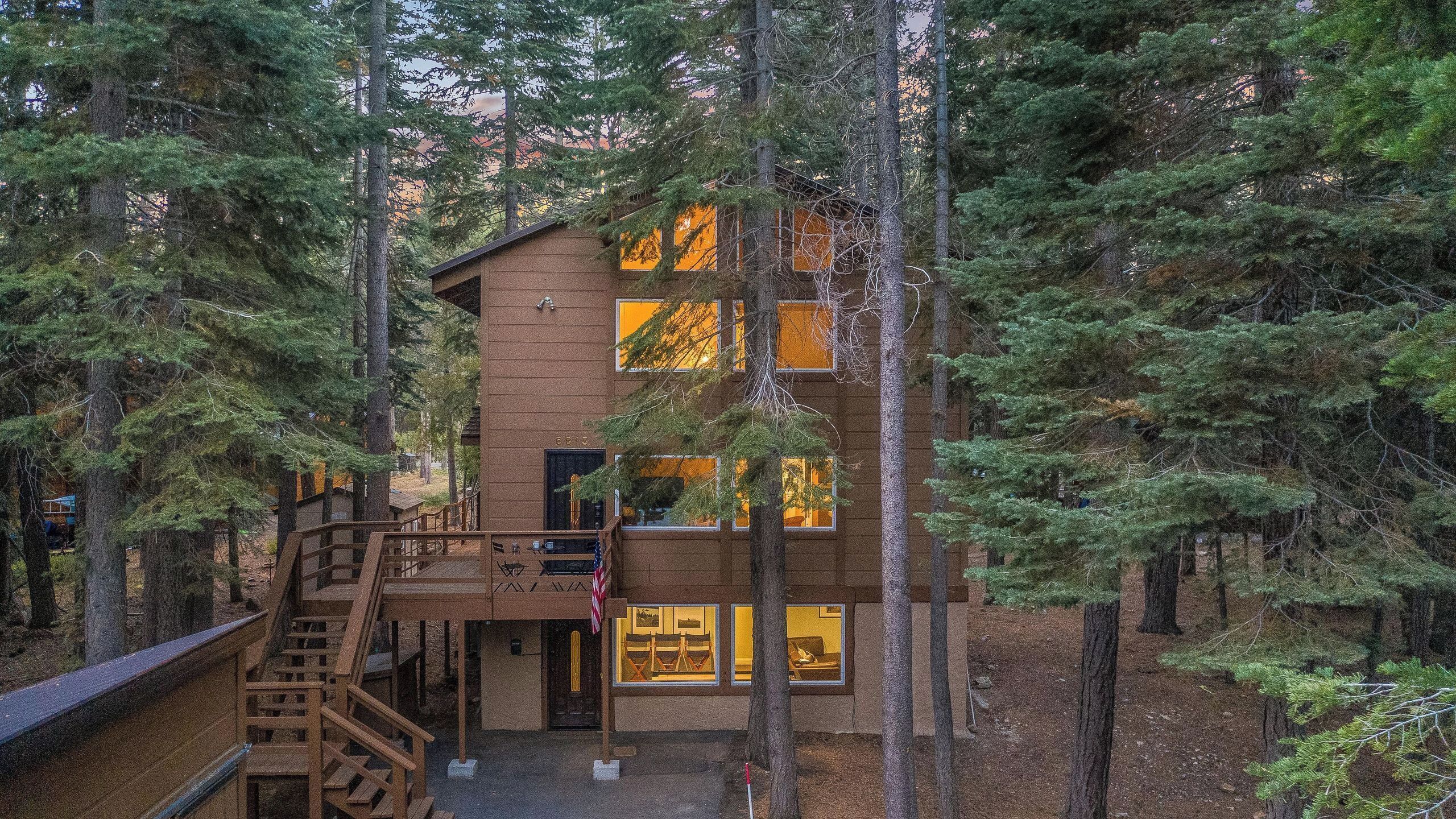 Une cabane avec une façade en bois, un escalier et des fenêtres.