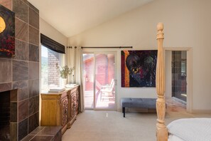 Een ruime kamer met een open haard, een bank en een groot schilderij.