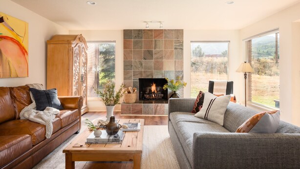 A living room with a fireplace, leather sofas, and large windows. - Picasso by Avantstay Artist's Mountain Escape w/ Hot Tub & Views (Park City)