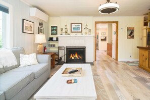 Ein Wohnzimmer mit Kamin, einer Couch, einem Couchtisch und einem Fernseher.