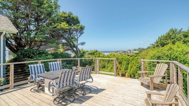 A wooden deck with a table and chairs, overlooking a coastal landscape. - Beach Pines Bungalow by Avantstay Classic Cottage Steps to the Beach w/ Private Yard (Arch Cape)