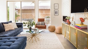 A living room with a sofa, armchair, coffee table, and a TV on a wall. - Marilyn by Avantstay Mins to Old Town La Quinta! (La Quinta)