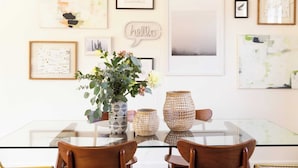 A dining area with a glass table, wooden chairs, and decorative vases. - Marilyn by Avantstay Mins to Old Town La Quinta! (La Quinta)
