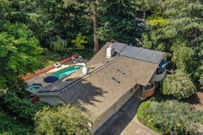A house with a swimming pool, solar panels, and a garden.