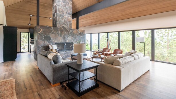 A spacious living room with a stone fireplace, two sofas, and a coffee table.