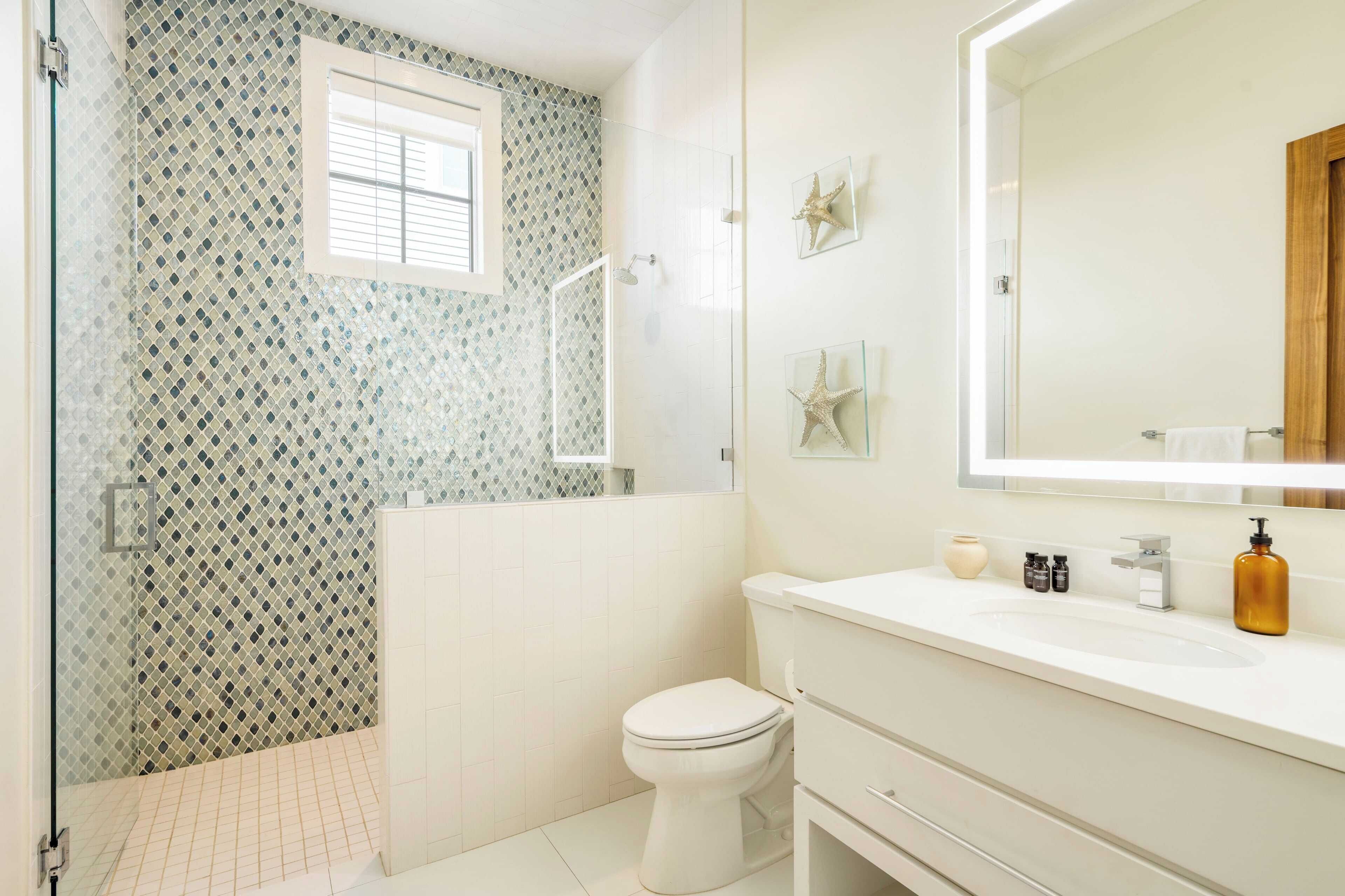 A bathroom with a shower, toilet, and sink.