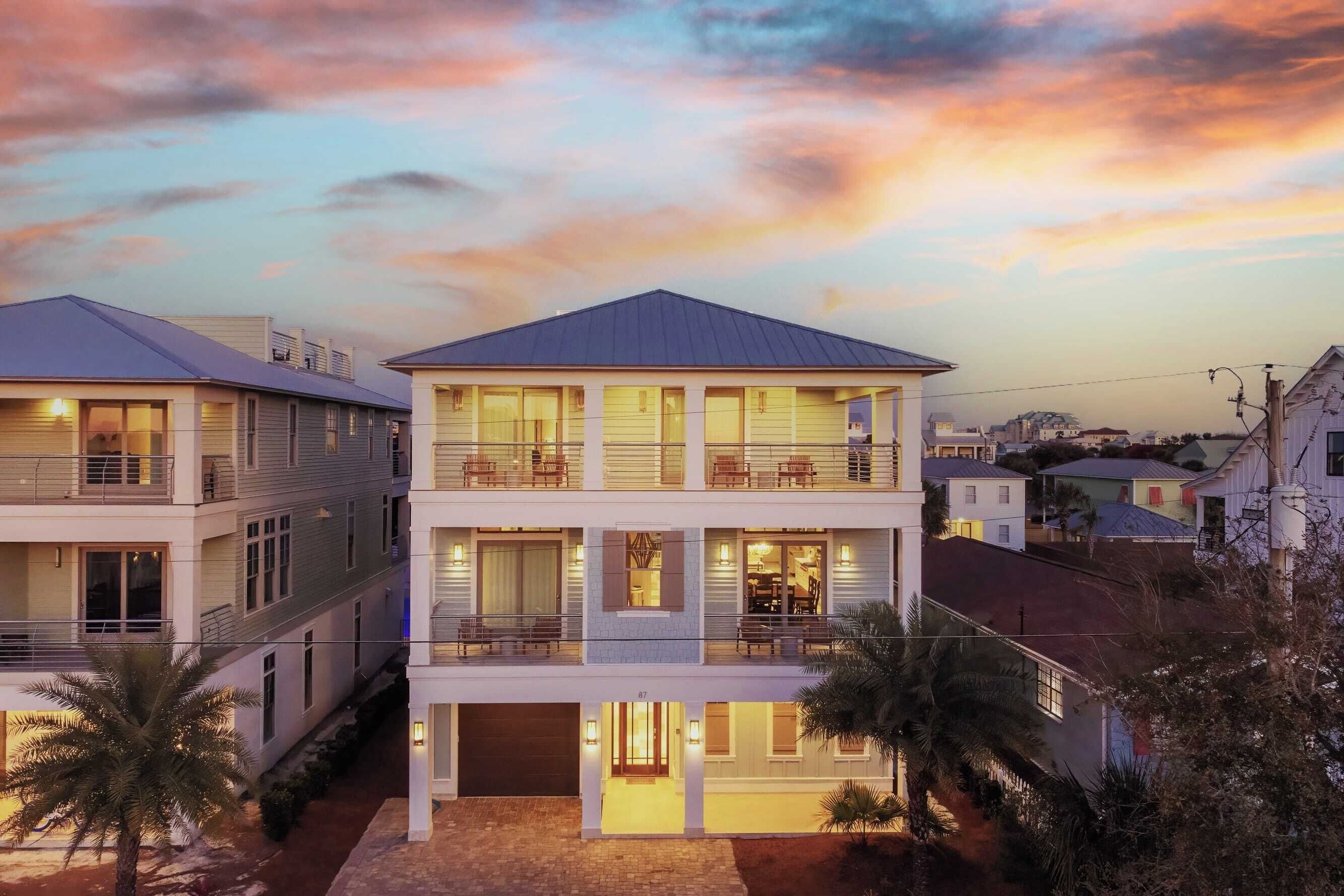 A multi-story residential building with balconies, large windows, and a well-lit entrance.