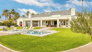 A modern house with a swimming pool, outdoor seating, and a well-maintained lawn. - Sunridge by Avantstay Glorious Scottsdale Estate w/ Pool, Hot Tub, Ping Pong & Pool Table! (Scottsdale)