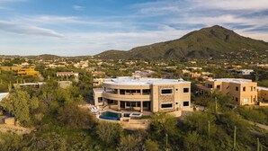 A multi-story building with a pool, surrounded by greenery and a mountain in the background. - Luxe Scottsdale Desert Oasis Infinity Pool, Spa, Panoramic Views + Firepit (Cave Creek)
