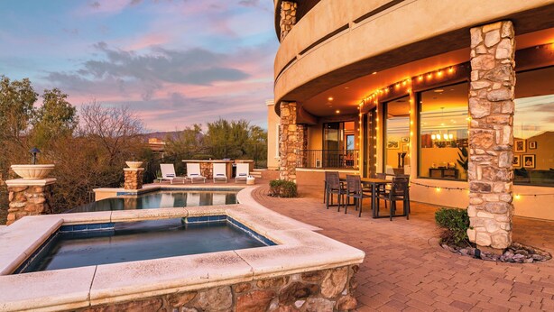A pool with a stone border, outdoor seating, and a stone pillar structure. - Luxe Scottsdale Desert Oasis Infinity Pool, Spa, Panoramic Views + Firepit (Cave Creek)