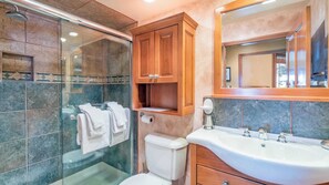 A bathroom with a glass shower enclosure, a toilet, a sink with a mirror above it, and wooden cabinets. - Etta Place Too 103 by Avantstay Close to Town & The Slopes! In Complex w/ Communal Pool & Hot Tub (Telluride)