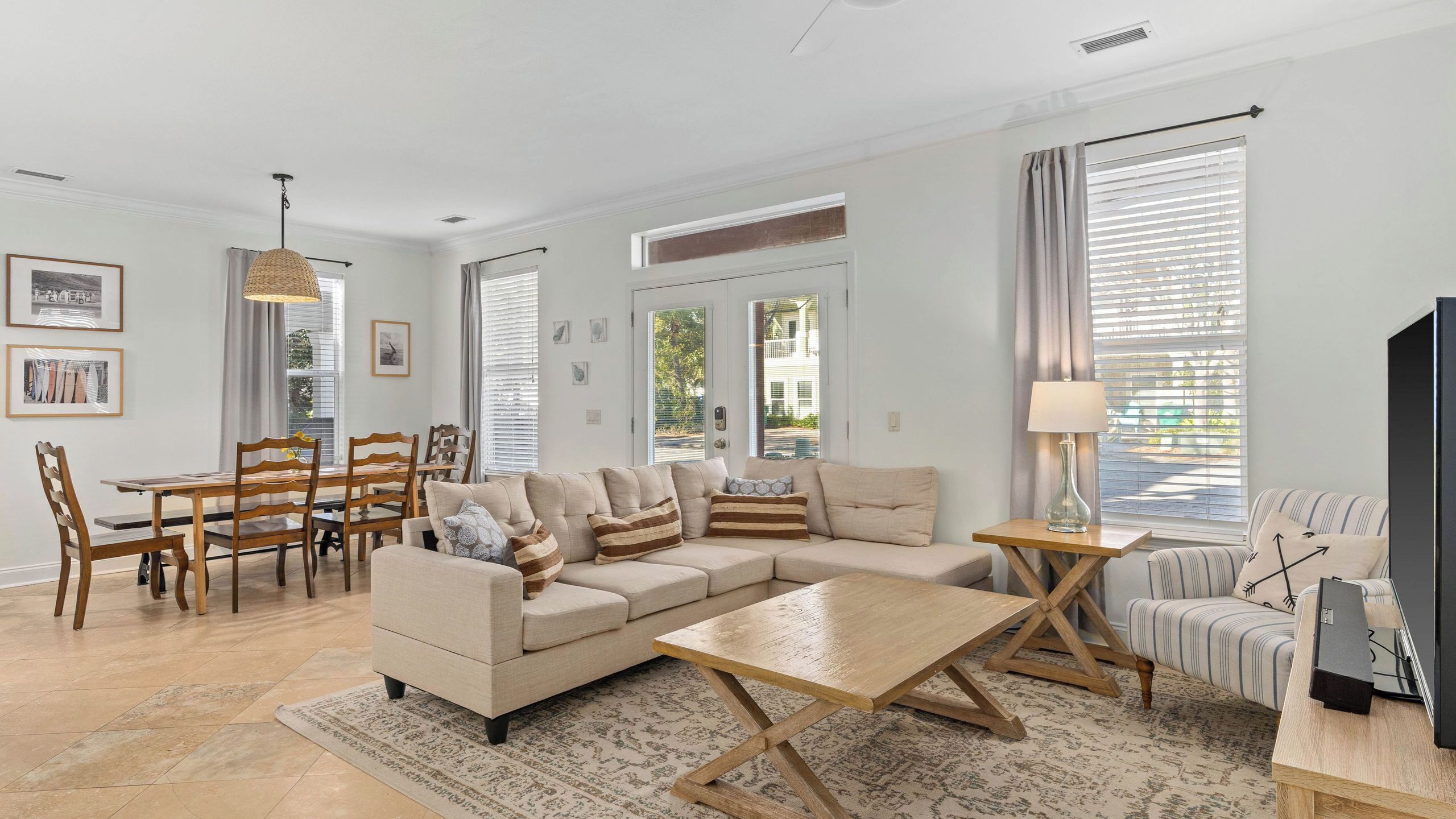 A living room with a sofa, coffee table, TV, and dining area with chairs and a table.