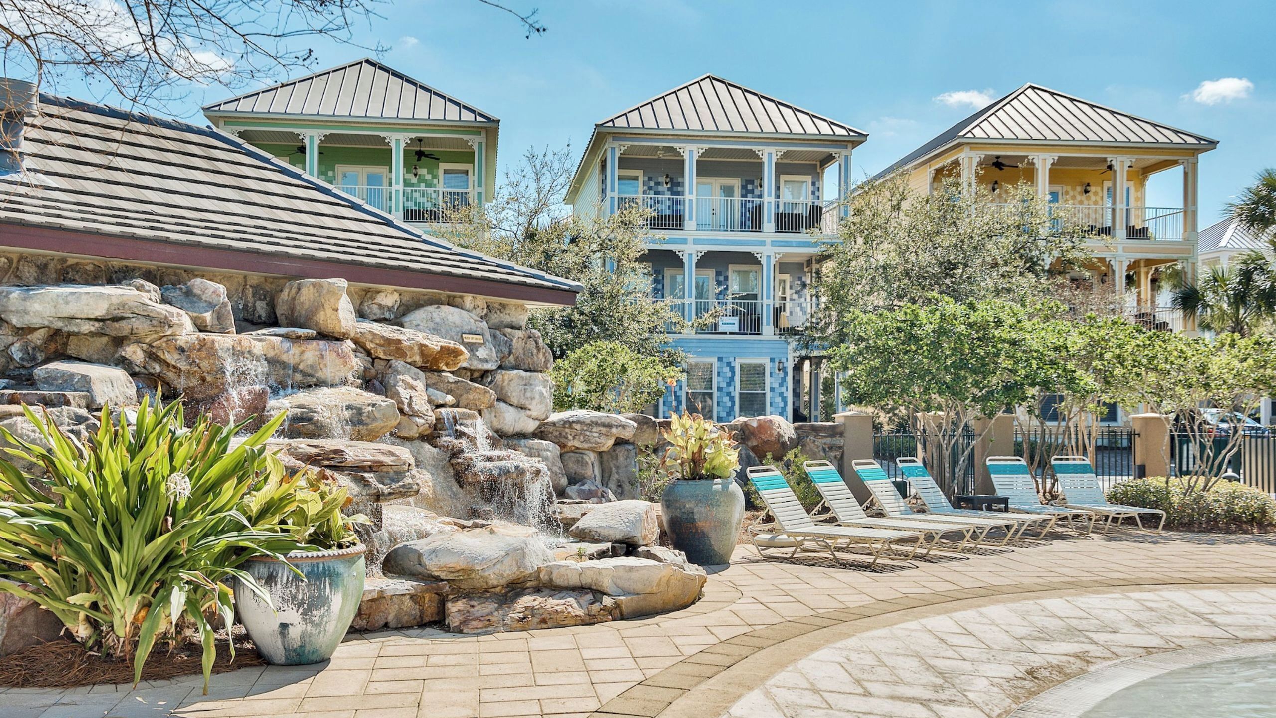 A resort with a pool area, stone walls, and multiple buildings with balconies.