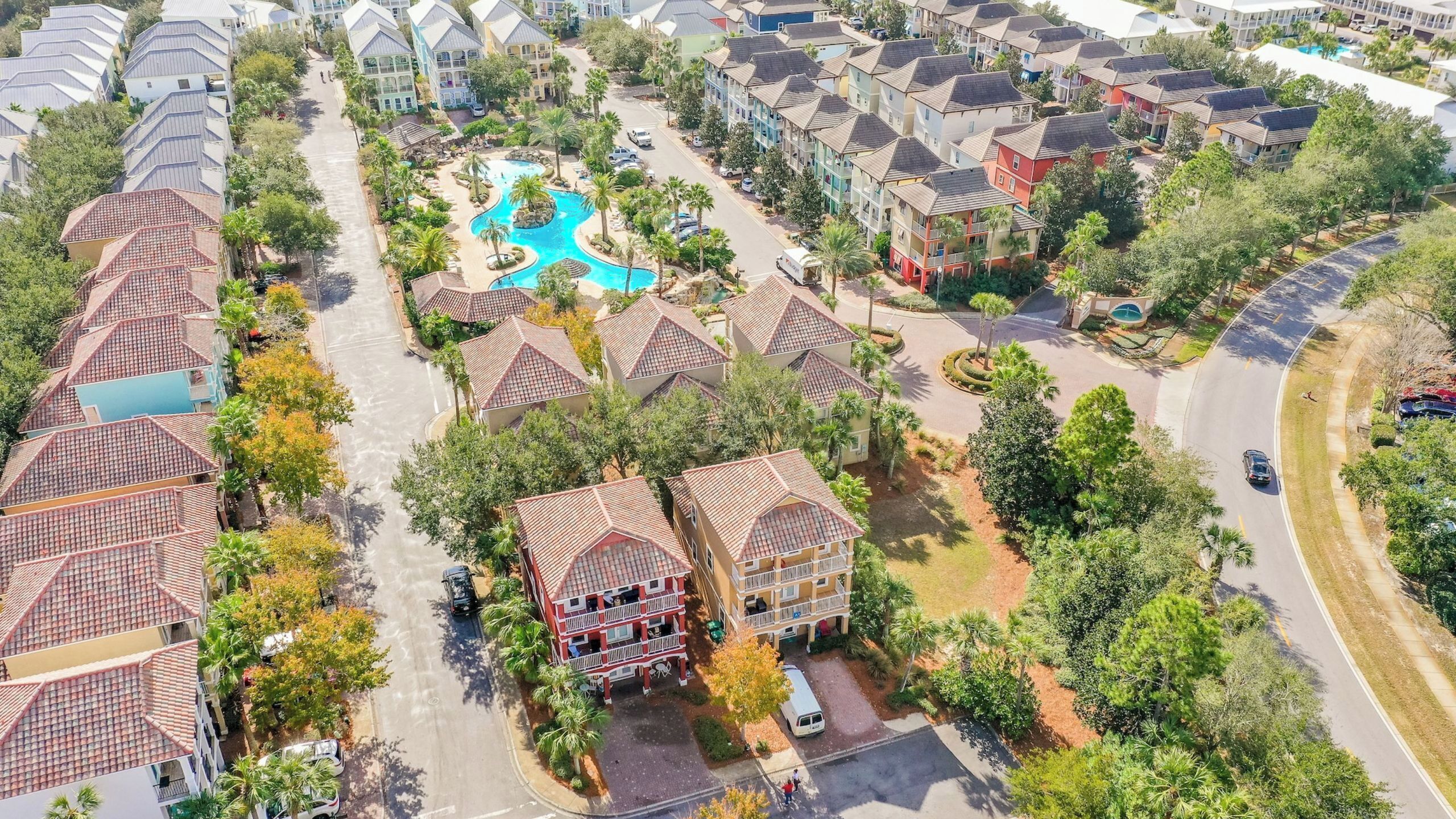 A residential area with a swimming pool, multiple-story buildings, and a curved road.