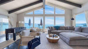 A spacious living room with a foosball table, a sofa, and a coffee table.