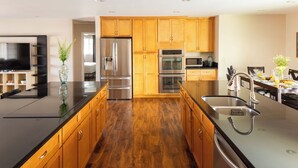 A modern kitchen with wooden cabinets, stainless steel appliances, and a black countertop. - West Ridge by Avantstay Pool, Fire Pit, Al Fresco Dining 7 Mins to Downtown (Scottsdale)