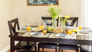 A dining table set with plates, glasses, and a vase of flowers. - West Ridge by Avantstay Pool, Fire Pit, Al Fresco Dining 7 Mins to Downtown (Scottsdale)