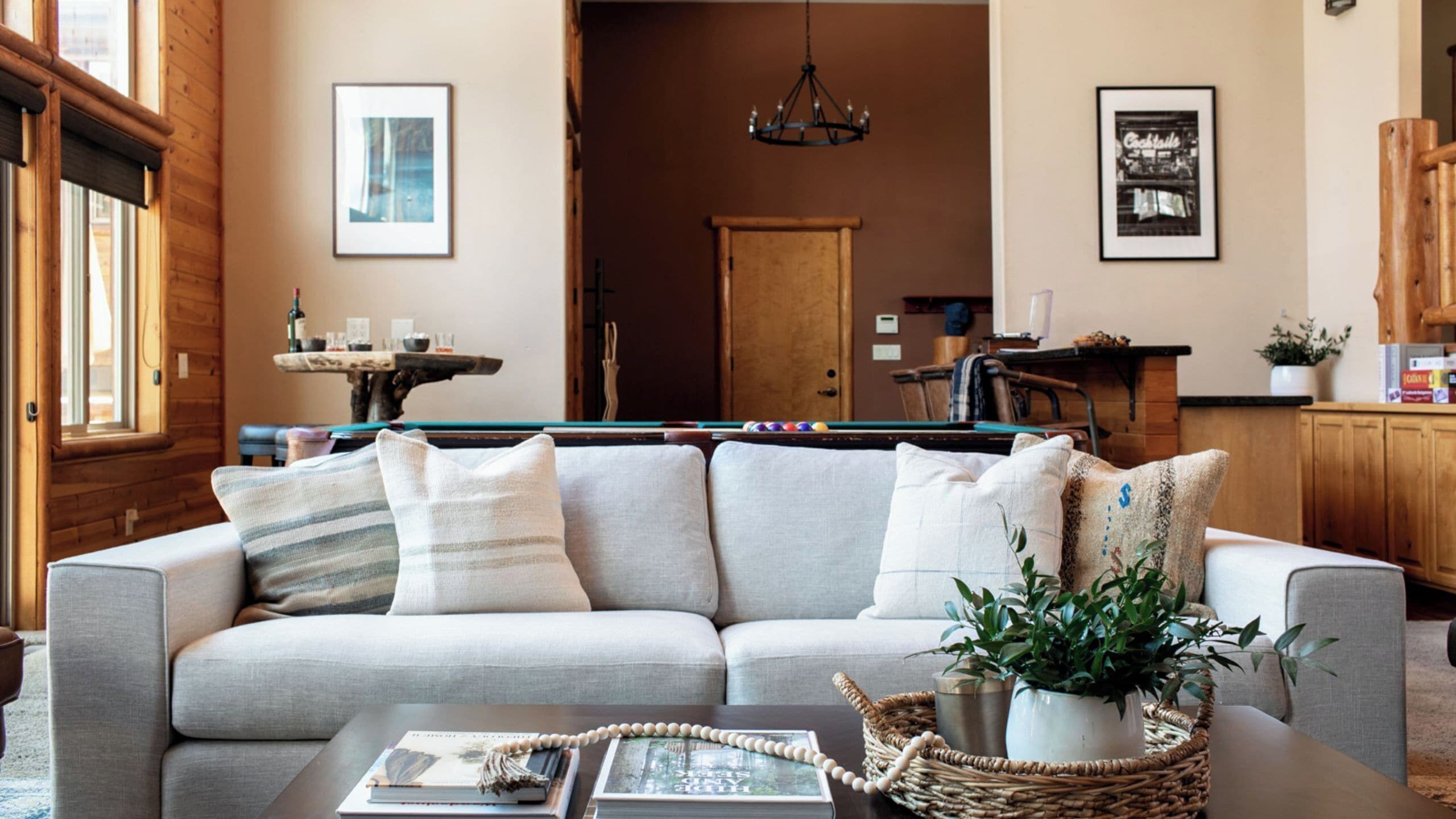 A living room with a sofa, a pool table, and a dining area.