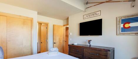 Una habitación de hotel con una cama, un aparador de madera, un televisor y un letrero en la pared.