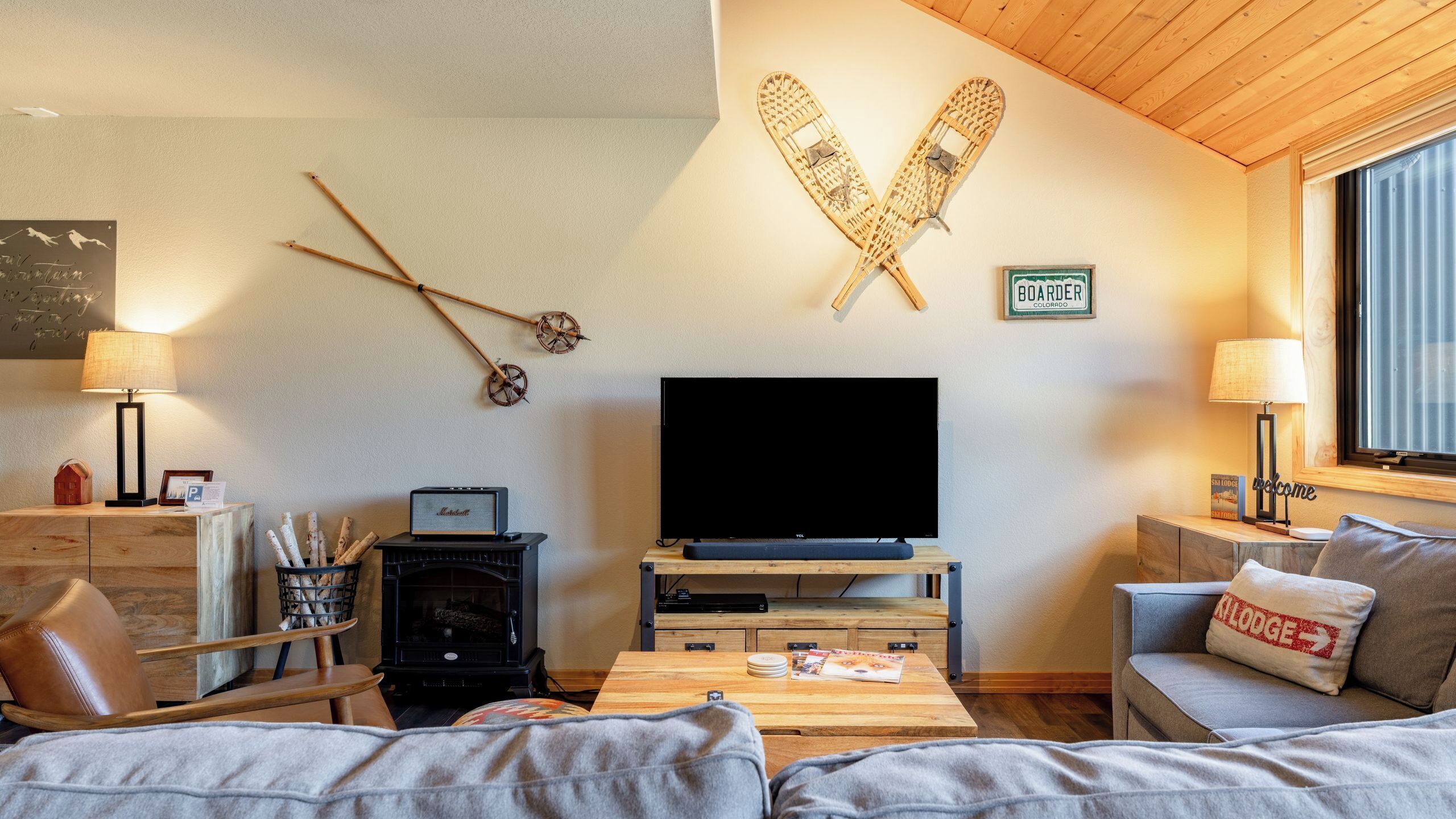 Una sala de estar acogedora con televisor, muebles de madera y chimenea.