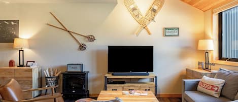 A cozy living room with a TV, wooden furniture, and a fireplace.