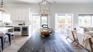 A spacious kitchen with white cabinets, a wooden island, and a hanging light fixture. - Fin by Avantstay 9 BR Destin Oasis With Pool & Spa Walk to Beach (Panama City Beach)