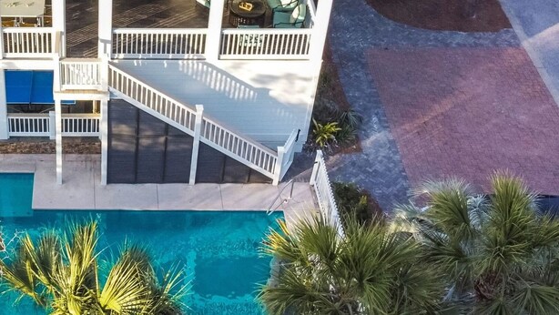 A multi-story hotel with balconies, a swimming pool, and palm trees. - Fin by Avantstay 9 BR Destin Oasis With Pool & Spa Walk to Beach (Panama City Beach)