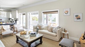 A spacious living room with a sofa, coffee table, and a dining area. - Fin by Avantstay 9 BR Destin Oasis With Pool & Spa Walk to Beach (Panama City Beach)