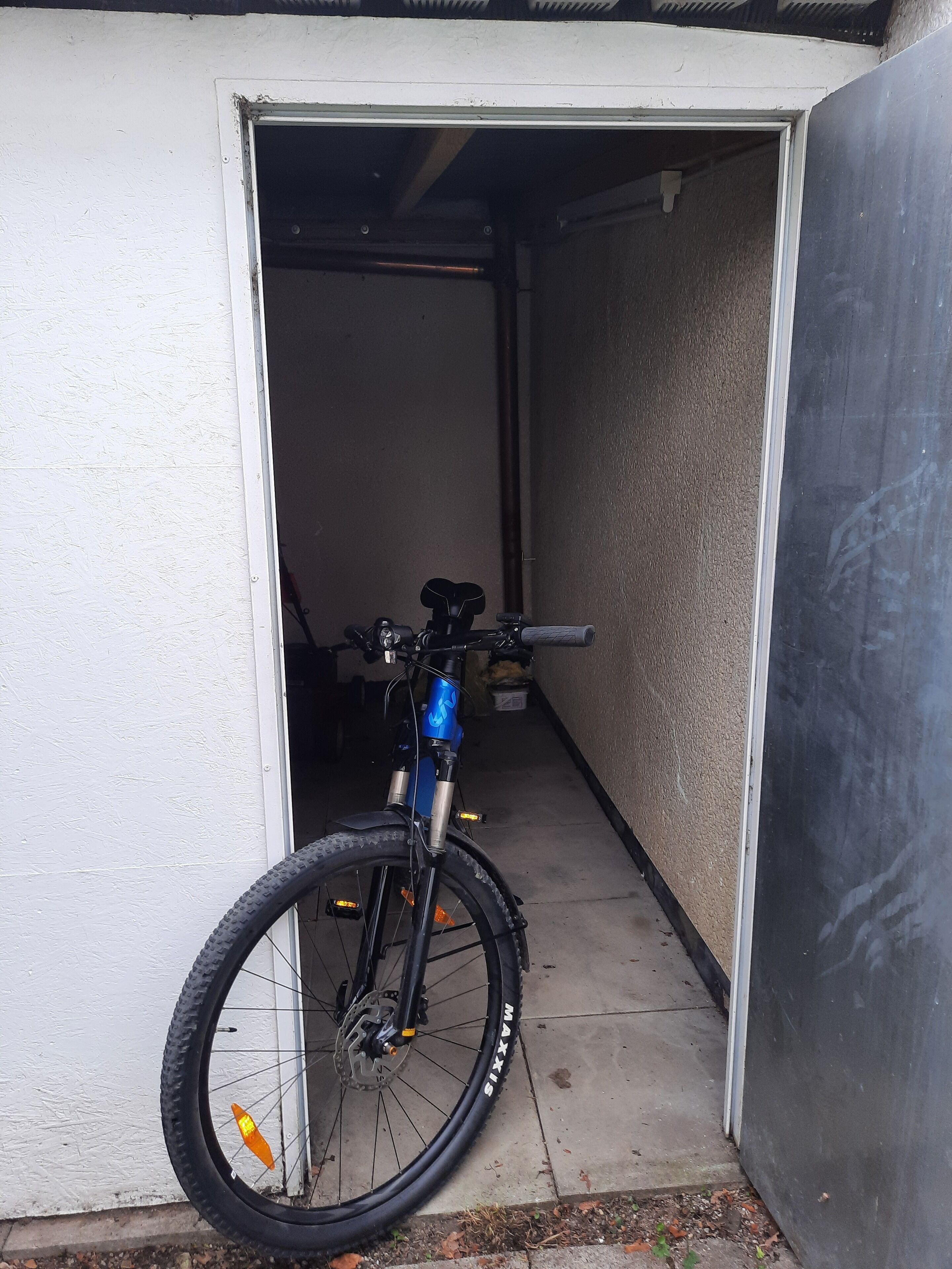 A bicycle parked in a narrow doorway.