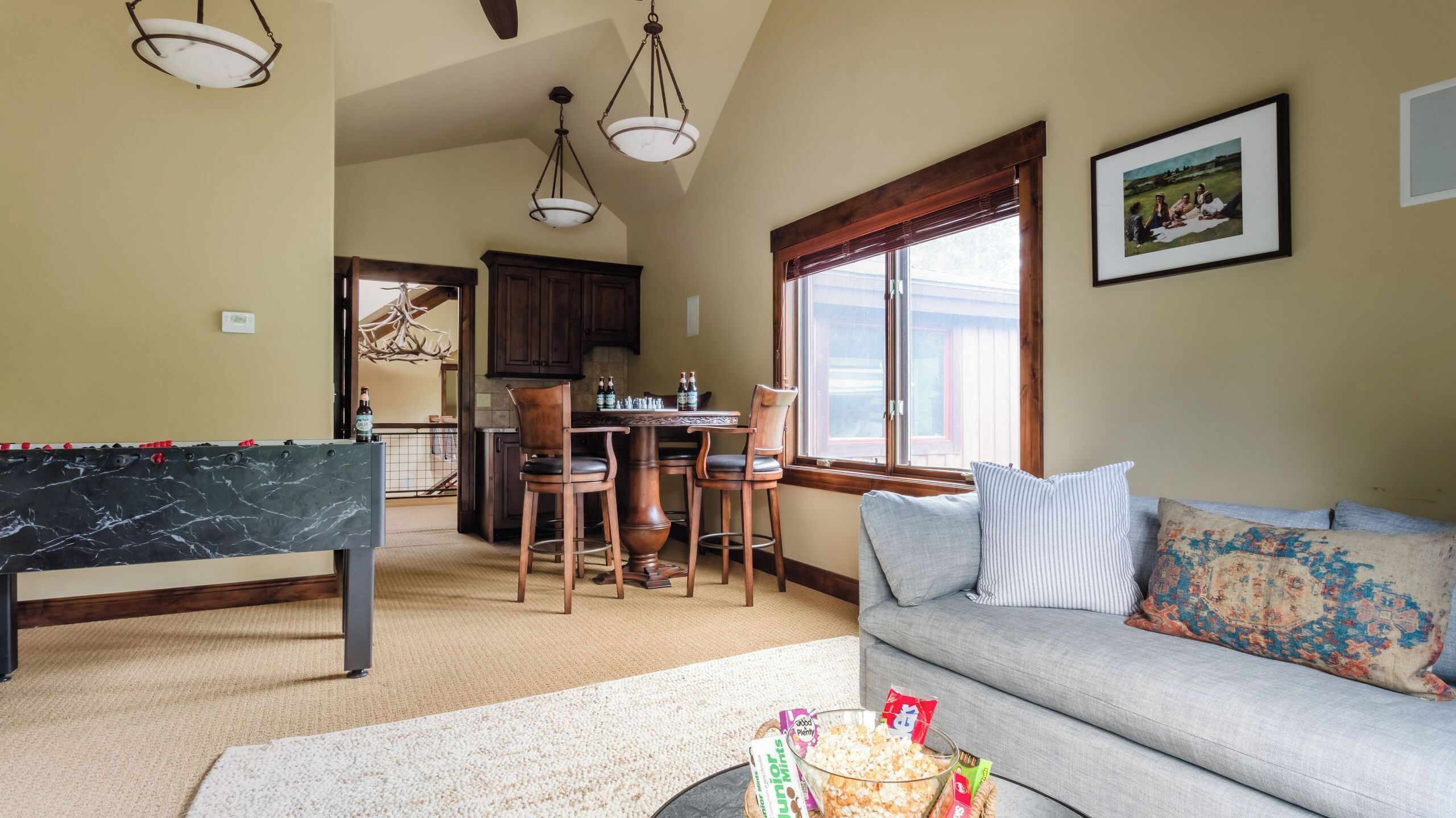 A living room with a pool table, a sofa, and a dining area with chairs and a table.