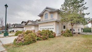 A two-story house with a garage, surrounded by a well-maintained lawn and shrubs. - Big family home w/ Deck, Ping Pong, BBQ & Garage (Edmonton)