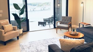 Un salón amplio con un gran ventanal, un ventilador de techo y vistas a un puente.