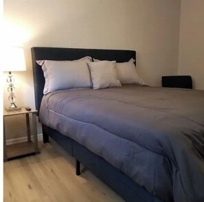 Cozy retreat with a single bed, bedside table, and lamp.