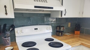 Una cocina con estufa blanca, encimeras de madera y salpicadero de azulejos.