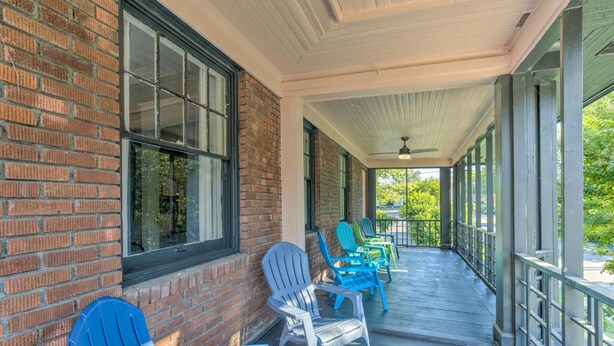 A covered porch with brick walls, large windows, and outdoor seating. - Tiny Trendy Traveler's Studio in Historic Midtown! (Memphis)